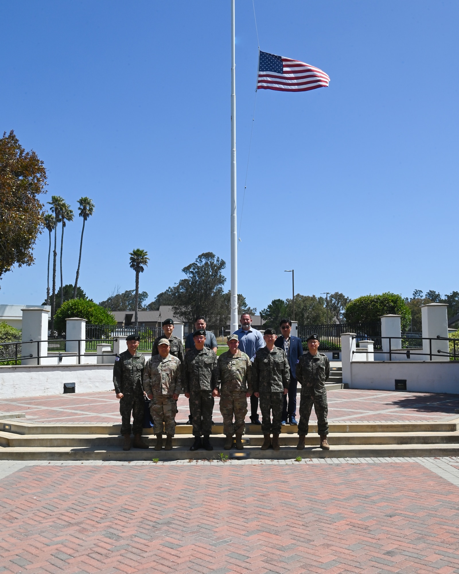 republic of korea officials and space forces korea commander pose in front of a us flag outside