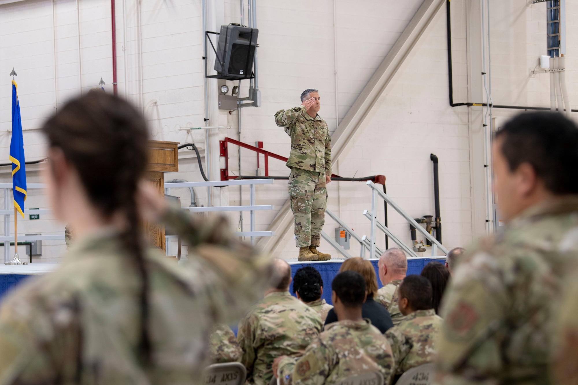 Lt. Col. John Valdes III renders his first salute as the commander of the 434th Maintenance Group from stage