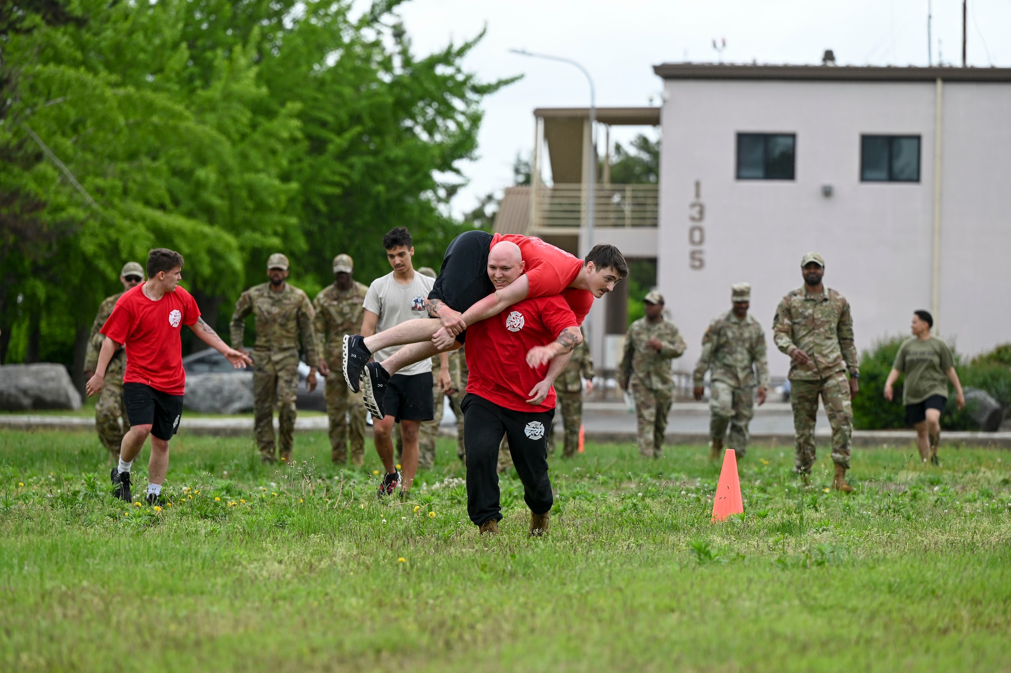 Airmen from the 8th Civil Engineer Squadron participate in fireman carries during the Police Week “Battle of the Pack” competition at Kunsan Air Base, Republic of Korea, May 16, 2025. The competition challenged teams to carry ammo cans, army crawl, fireman carry teammates and complete a humvee push.