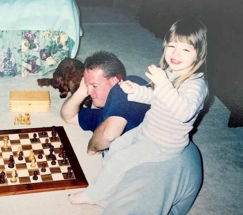 Sgt. 1st Class John Beale and his daughter, Cayle, play chess together on the floor of their home.
