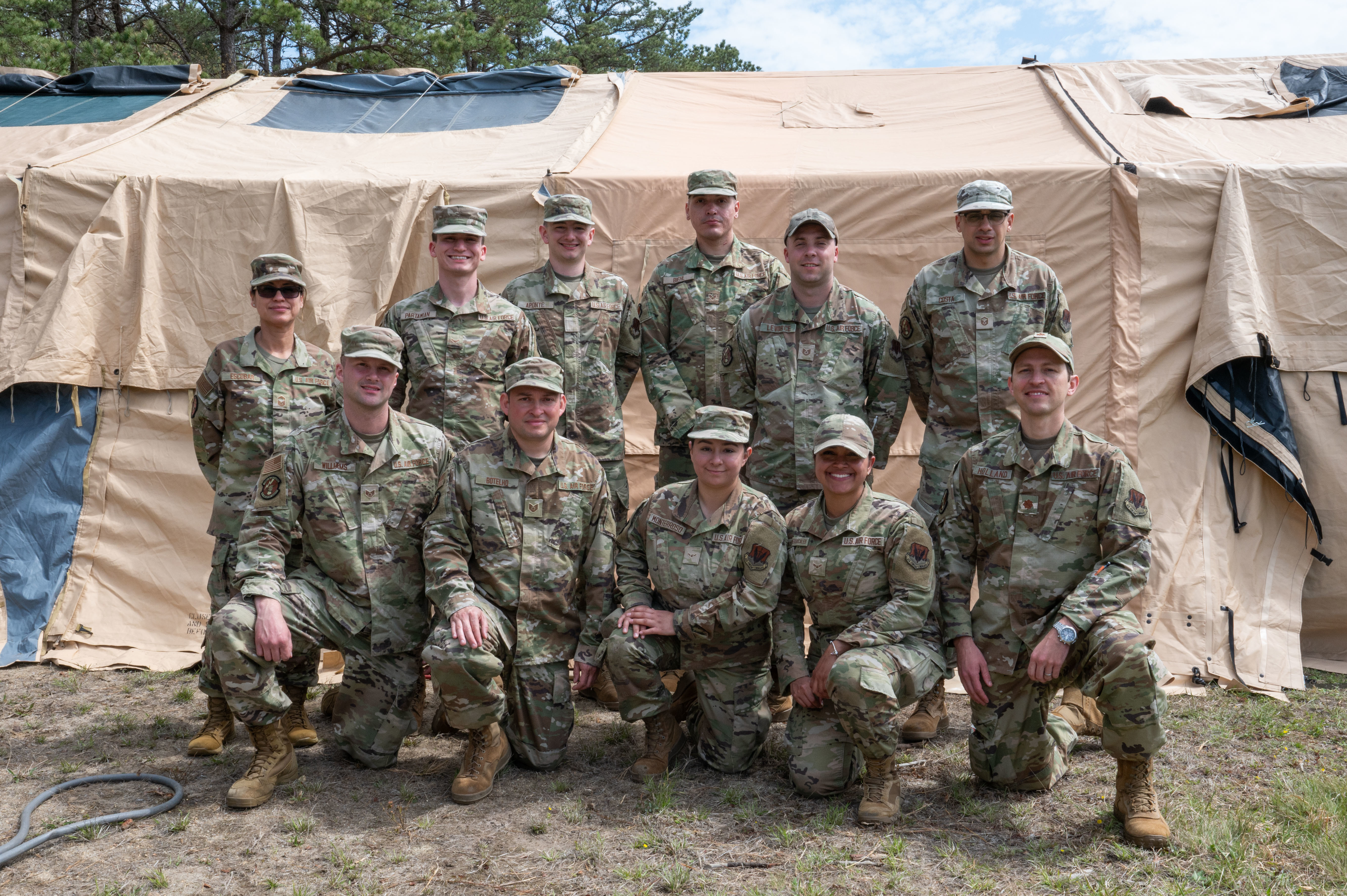 102nd Intelligence Wing services specialists pose for a group photo during Exercise Iron Nomad, a large-scale, three-day training operation on Otis Air National Guard Base, Massachusetts, May 2, 2025. During the training event, the Airmen learned how to set up and operate key base support systems, including a Single Palletized Expeditionary Kitchen and Mortuary Affairs Collection Point. (Air National Guard photo by Senior Airman Julia Ahaesy)