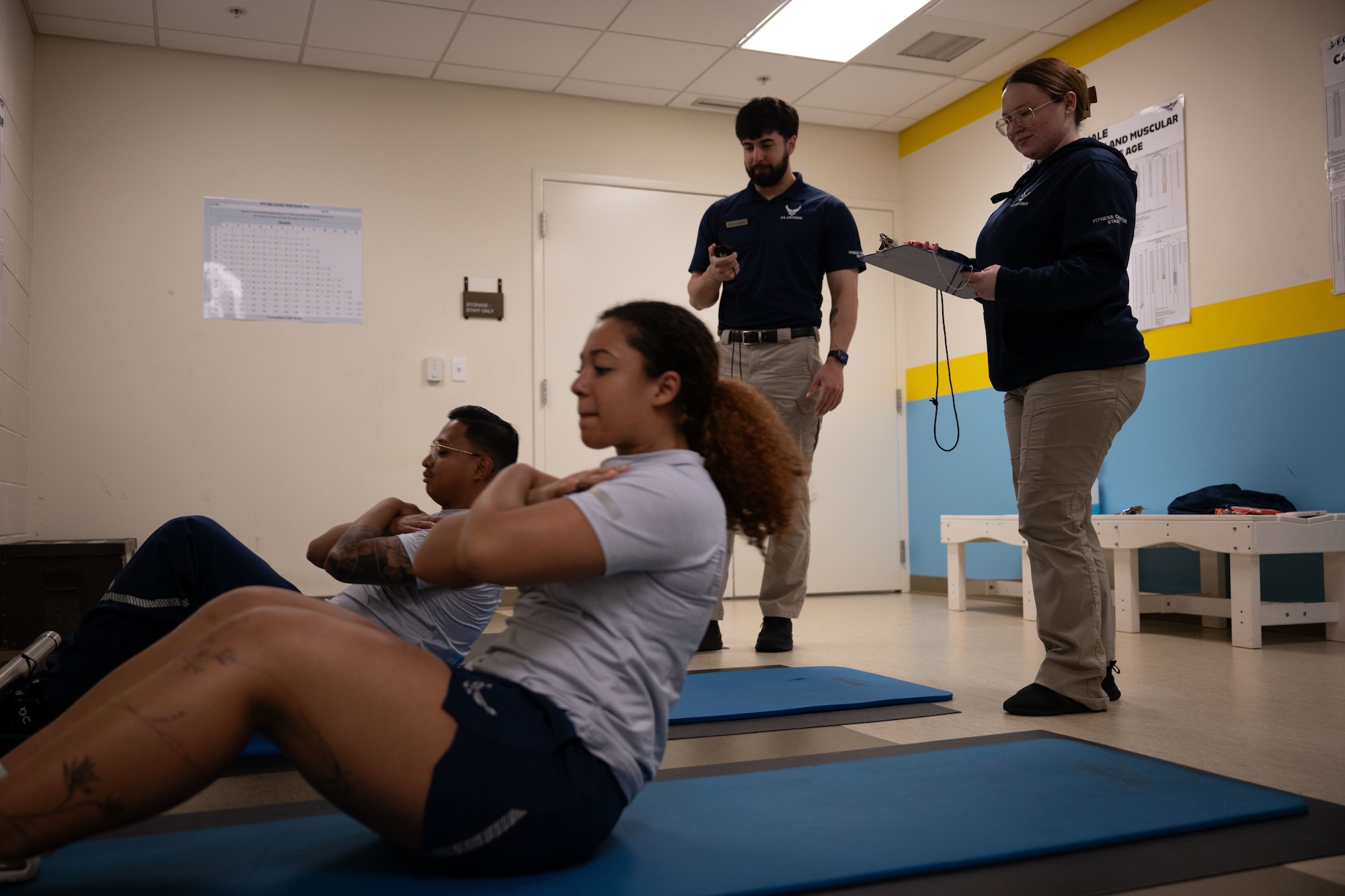 U.S. Air Force Senior Airman Kaylee Jordan, right, 436th Force Support Squadron fitness specialist, and Staff Sgt. Christopher Denney, center, 436th FSS fitness noncommissioned officer in charge, administer a physical fitness assessment at Dover Air Force Base, Delaware, May 15, 2025. The Fitness Center offers a range of exercise equipment, classes and programs designed to improve physical fitness and overall health. (U.S. Air Force photo by Airman 1st Class Liberty Matthews)