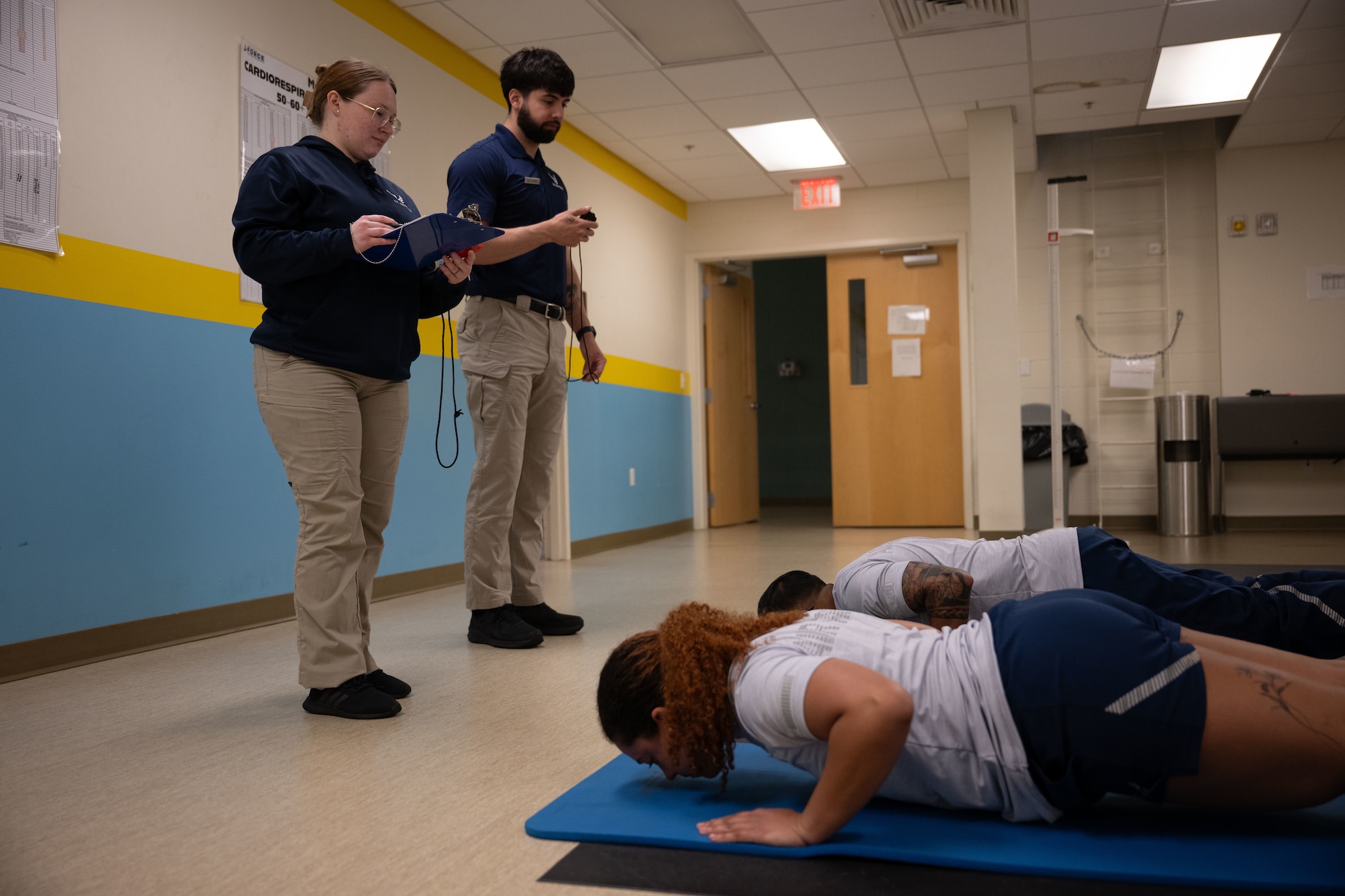 U.S. Air Force Senior Airman Kaylee Jordan, left, 436th Force Support Squadron fitness specialist, and Staff Sgt. Christopher Denney, center, 436th FSS fitness noncommissioned officer in charge, administer a physical fitness assessment at Dover Air Force Base, Delaware, May 15, 2025. The Fitness Center offers a range of exercise equipment, classes and programs designed to improve physical fitness and overall health. (U.S. Air Force photo by Airman 1st Class Liberty Matthews)