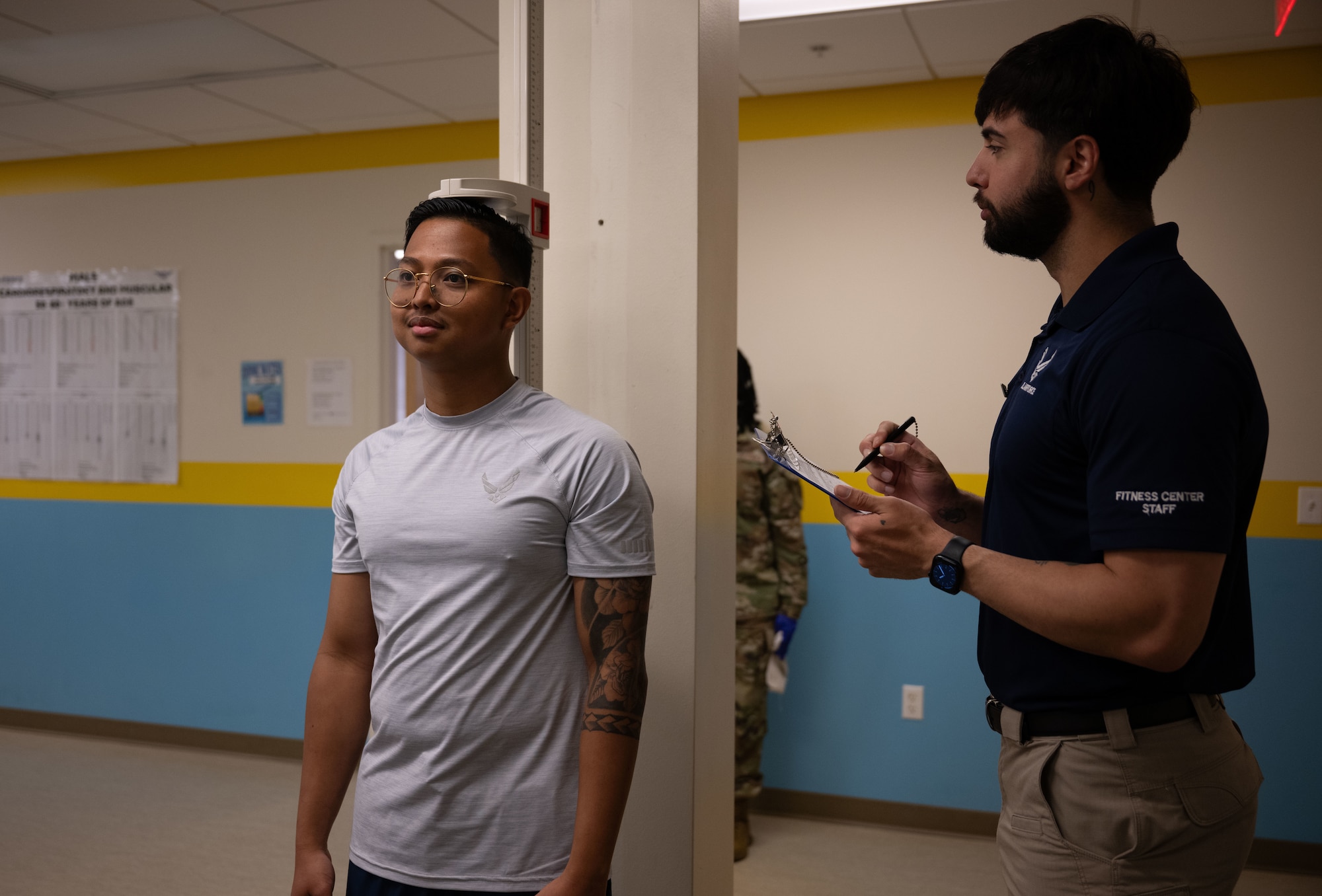 U.S. Air Force Staff Sgt. Christopher Denney, right, 436th Force Support Squadron fitness noncommissioned officer in charge, measures a Team Dover member’s height at the Fitness Center on Dover Air Force Base, Delaware, May 15, 2025. The Fitness Center offers a range of exercise equipment, classes and programs designed to improve physical fitness and overall health. (U.S. Air Force photo by Airman 1st Class Liberty Matthews)