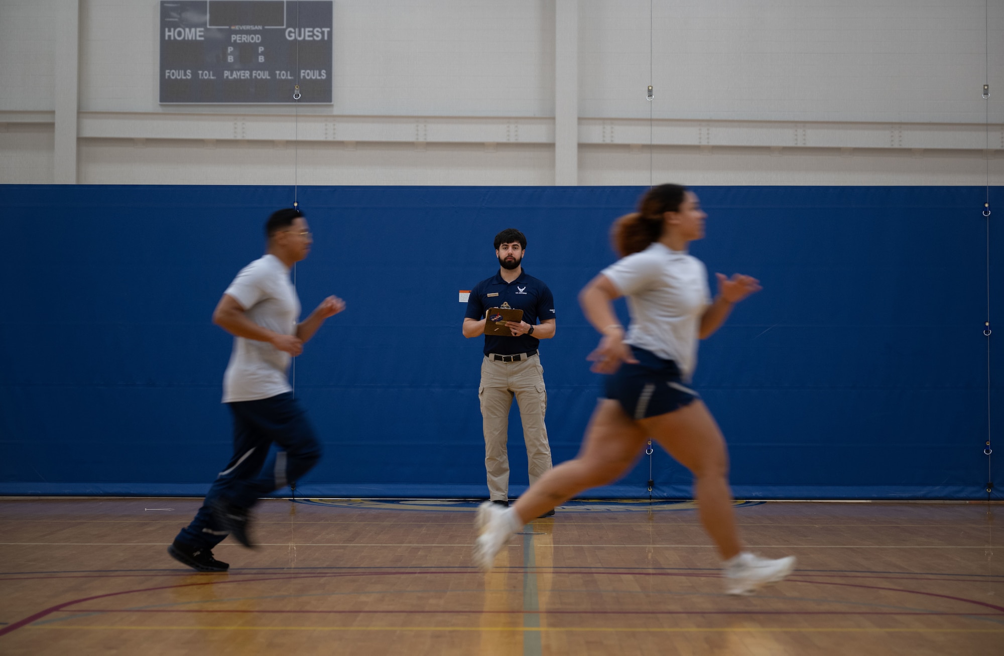 U.S. Air Force Staff Sgt. Christopher Denney, center, 436th Force Support Squadron fitness noncommissioned officer in charge, administers the High Aerobic Multi-Shuttle Run at the Fitness Center on Dover Air Force Base, Delaware, May 15, 2025. The Fitness Center offers a range of exercise equipment, classes and programs designed to improve physical fitness and overall health. (U.S. Air Force photo by Airman 1st Class Liberty Matthews)