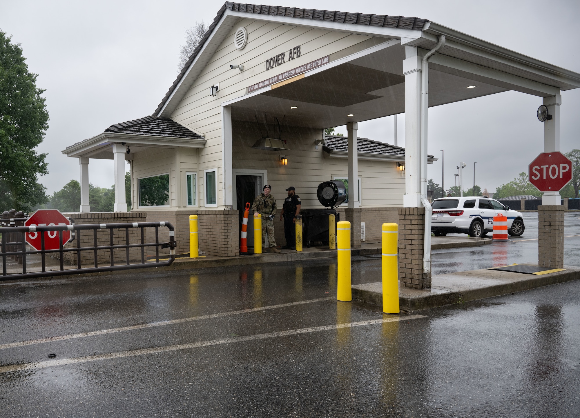 U.S. Airman 1st Class Miranda Graham, left, 436th Security Forces Squadron response force member, and Joshua Brown, Department of the Air Force Police officer, wait for vehicles to arrive at the housing gate at Dover Air Force Base, Delaware, May 14, 2025. The motto “defensor fortis” means “strong defender,” the official motto of SF, defining the concept of strength in adversity, taught to members of SF. (U.S. Air Force photo by Airman 1st Class Liberty Matthews)