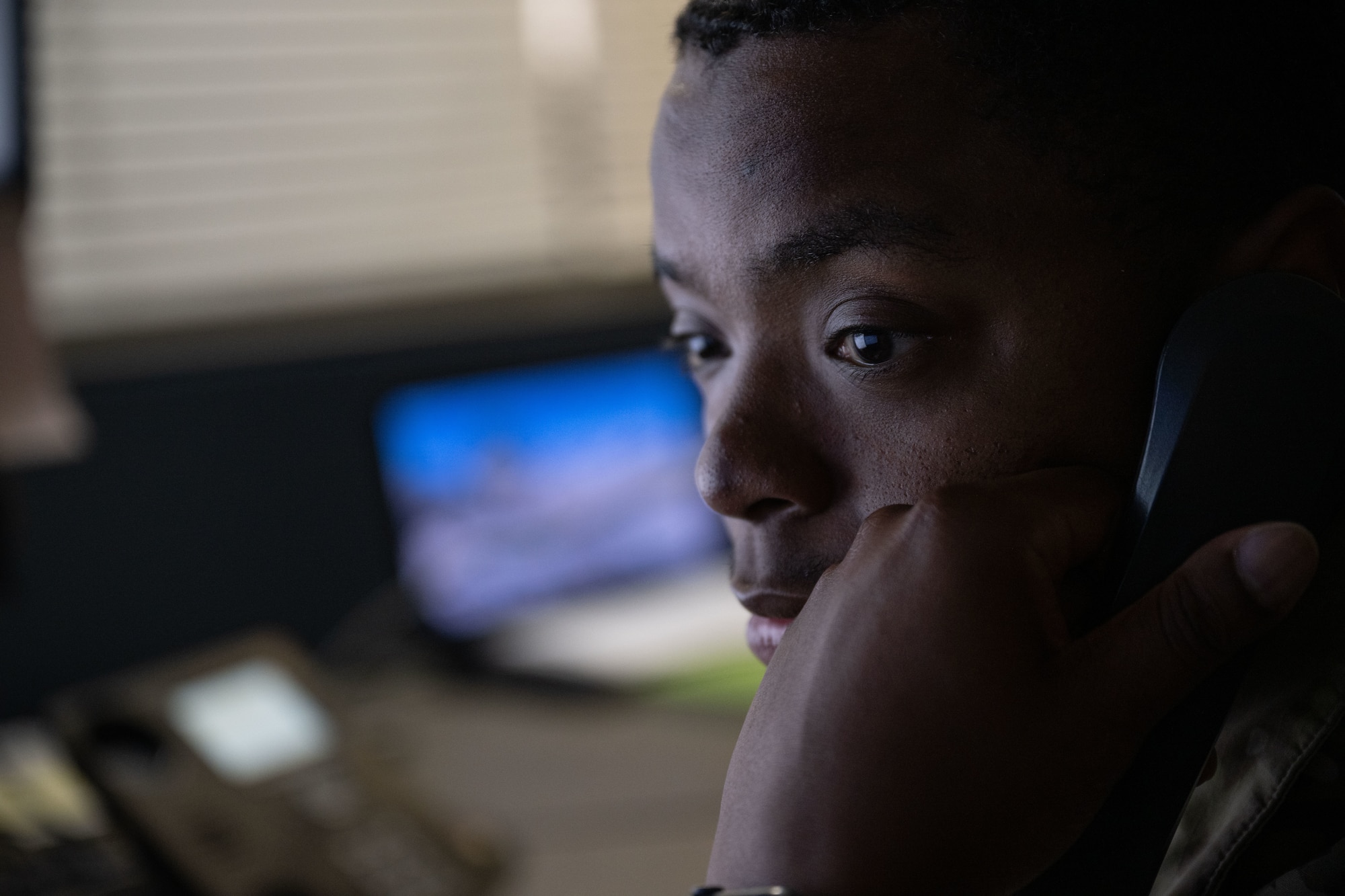 U.S. Air Force Senior Airman Winston Harris, 436th Security Forces Squadron base defense operations center member, listens to the phone at Dover Air Force Base, Delaware, May 14, 2025. The motto “defensor fortis” means “strong defender,” the official motto of SF, defining the concept of strength in adversity, taught to members of SF. (U.S. Air Force photo by Airman 1st Class Liberty Matthews)