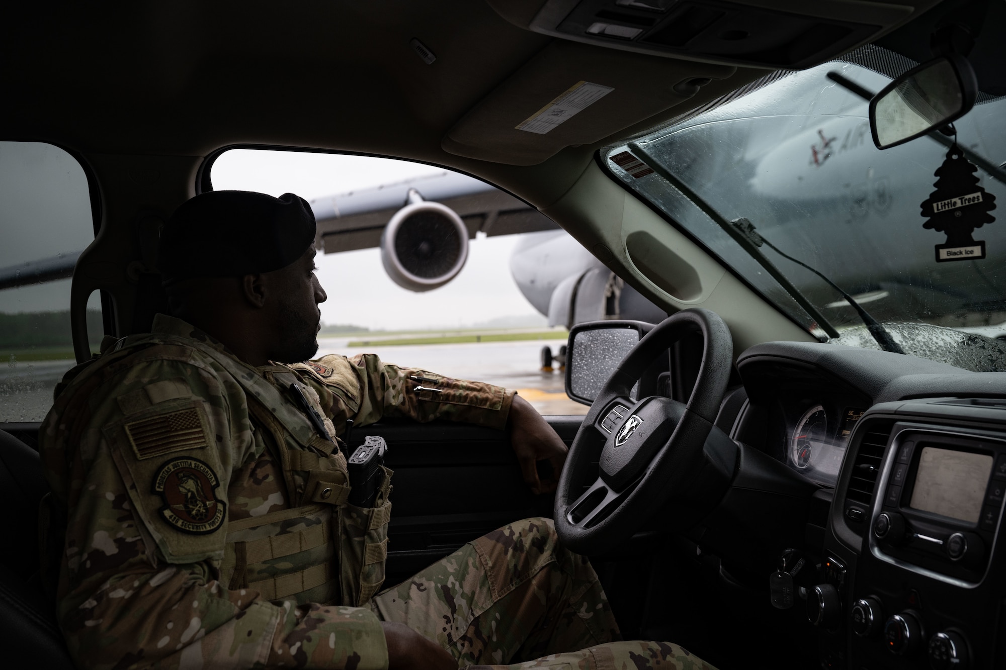 U.S. Airman 1st Class Sheamar Smith, 436th Security Forces Squadron response force member, watches over C-5M Super Galaxy operations in a patrol truck at Dover Air Force Base, Delaware, May 14, 2025. The motto “defensor fortis” means “strong defender,” the official motto of SF, defining the concept of strength in adversity, taught to members of SF. (U.S. Air Force photo by Airman 1st Class Liberty Matthews)