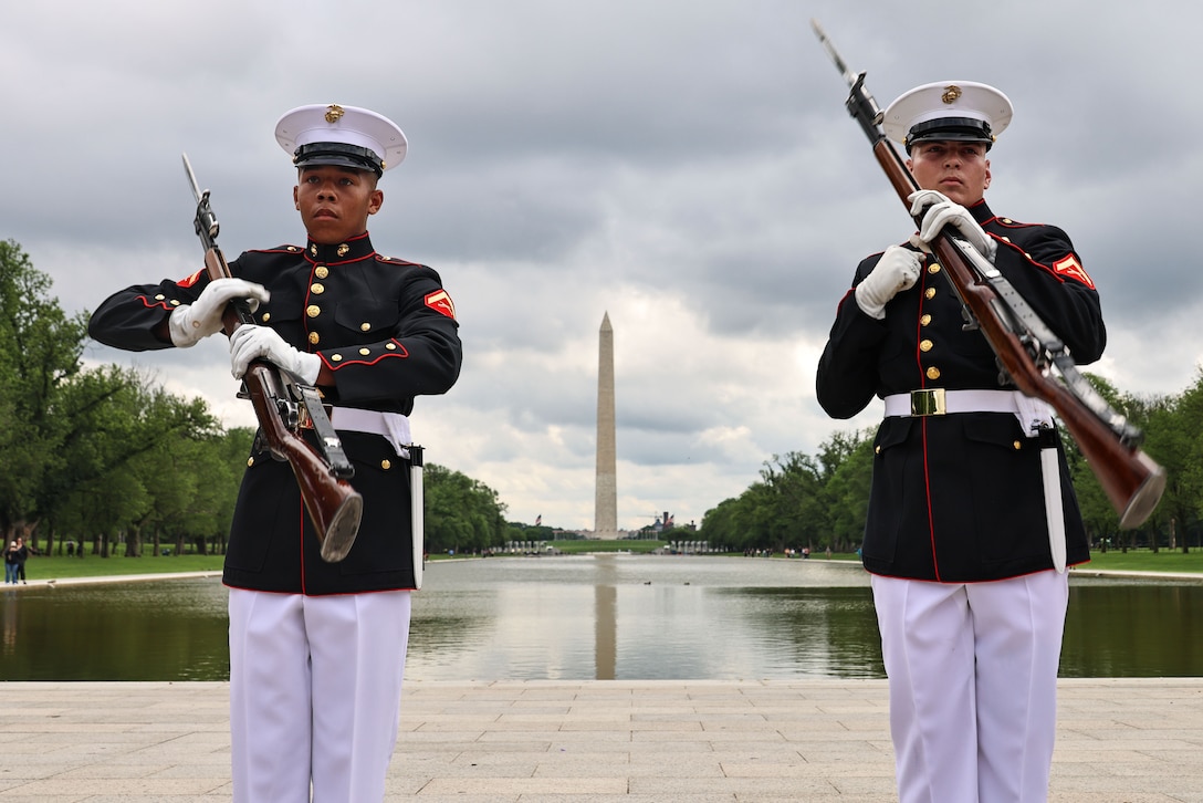 U.S. Marine Corps Lance Cpl. Caleb Hall, left, and Lance Cpl. Colby Decaney, both with the United States Marine Corps Silent Drill Platoon, execute their "long line" sequence during a performance for the Veterans Honor Flight of Southern Illinois in Washington D.C., May 6, 2025. The Silent Drill Platoon performed in honor of the visiting veterans, demonstrating the Marine Corps' ceremonial and military drill excellence with their precise rifle movements. (U.S. Marine Corps photo by Lance Cpl. Christopher Prelle)