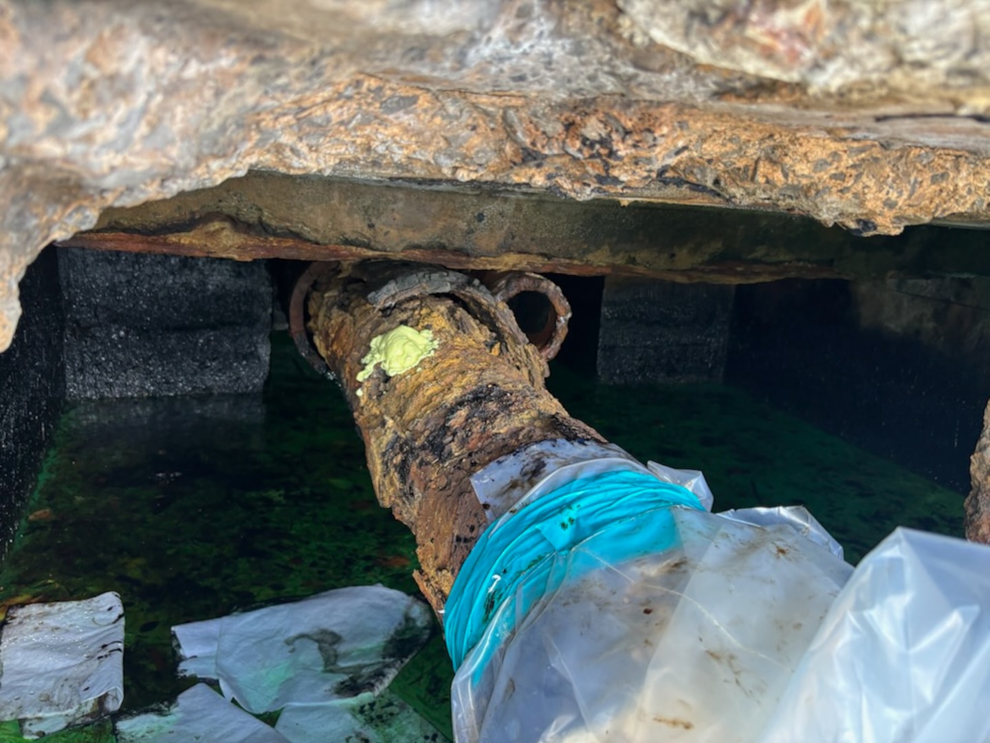 Photo of legacy pipe discharging oil, wrapped in plastic and absorbent boom, between Piers 2 and 3 in San Juan Harbor, Puerto Rico. Since April 11, 2025, Coast Guard Sector San Juan’s Incident Management team is investigating, responding and working with contracted oil spill removal organizations and local government authorities to contain and mitigate the pollution threat and clean up any recoverable product.  (U.S. Coast Guard photo)