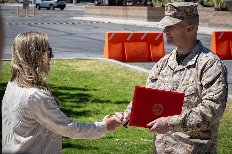 U.S. Marine Corps Brig. Gen. Mark Clingan, commanding general of Marine Air Ground Task Force Training Command, Marine Corps Air Ground Combat Center, right, congratulates Nicole Hitch, a Missouri native, community liaison with G-7, Government and External Affairs, MAGTFTC, MCAGCC, after her award ceremony for the 2024 Training and Education Command Junior Civilian of the Year at Lance Cpl. Torrey Gray Field, MCAGCC, Twentynine Palms, California, May 13, 2025.