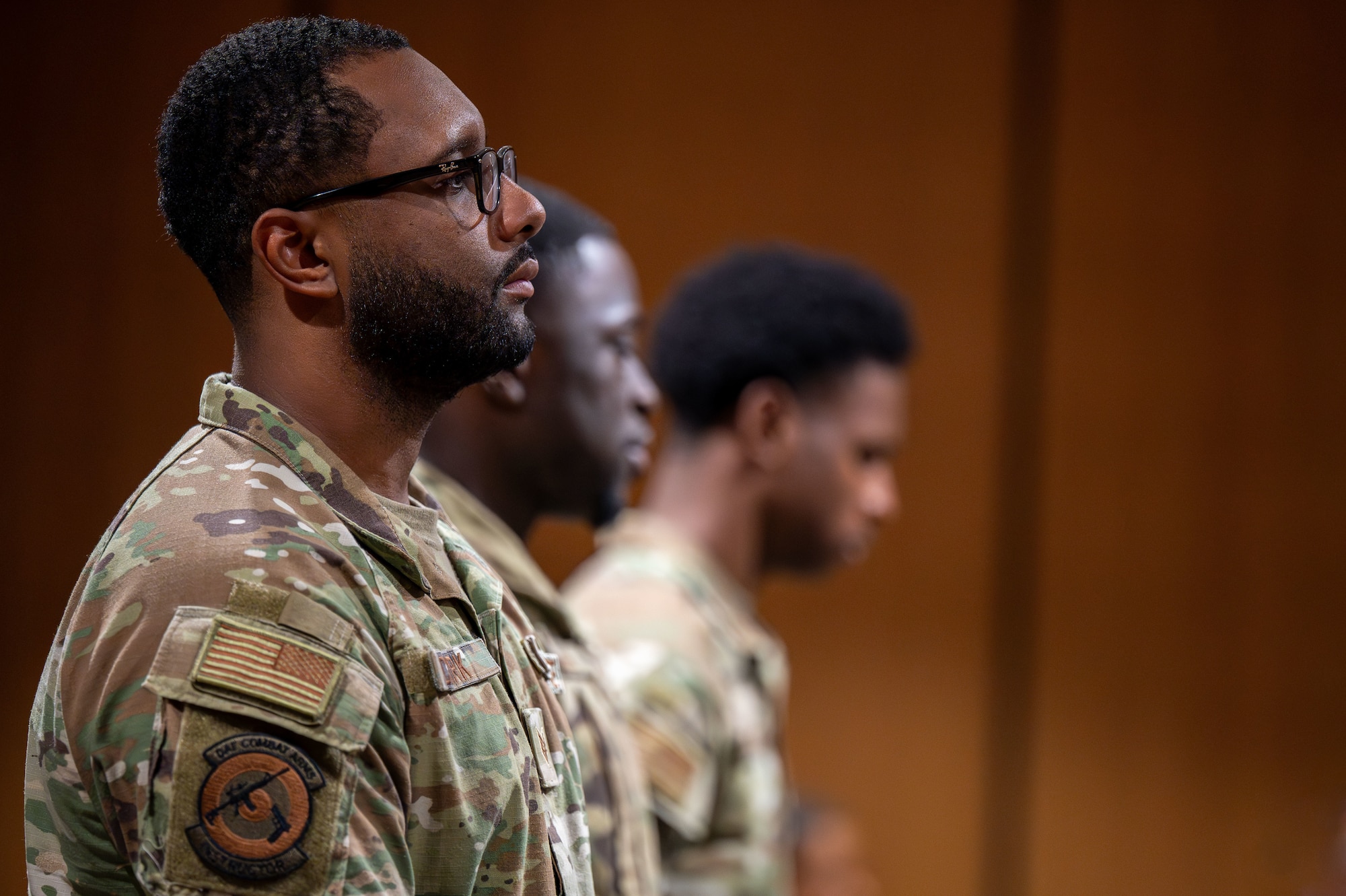 U.S. Airmen assigned to the 355th Security Forces Squadron stand as fallen Defenders are honored during a Final Guard Mount ceremony at Davis-Monthan Air Force Base, Arizona, May 16, 2025. This tribute mirrors the daily guard mount, where Defenders are armed and briefed before their shift, but includes calling the names of the fallen, to which only silence responds. (U.S. Air Force photo by Senior Airman Jasmyne Bridgers-Matos)