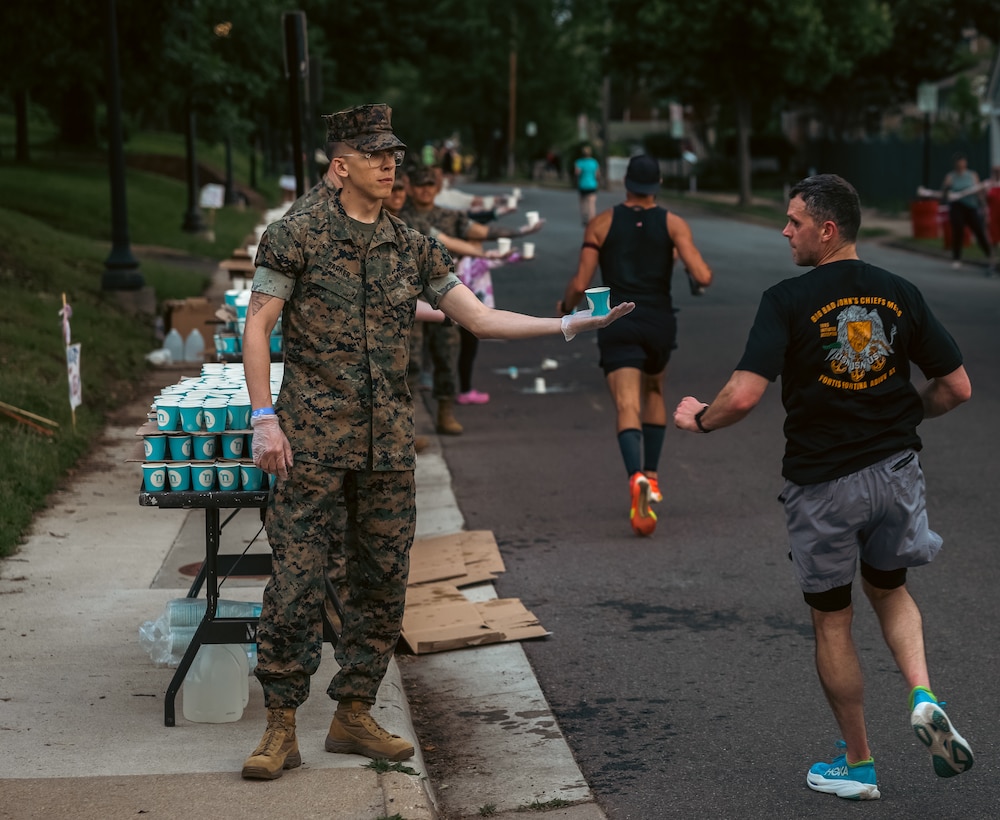 U.S. Marine Corps Cpl. Joshua Barker, a combat photographer with Training and Education Command, hands out water during the 2025 Marine Corps Historic Half in Fredericksburg, Virginia, May 18, 2025. The Historic Half is a 13.1-mile race weaved throughout Historic Downtown Fredericksburg, home to over 200 stores and several historic sites. The race generates community goodwill, fosters public relations, and increases advocacy for individual health while emphasizing the Marine Corps’ warrior ethos. (U.S. Marine Corps photo by Lance Cpl. Ethan Miller)