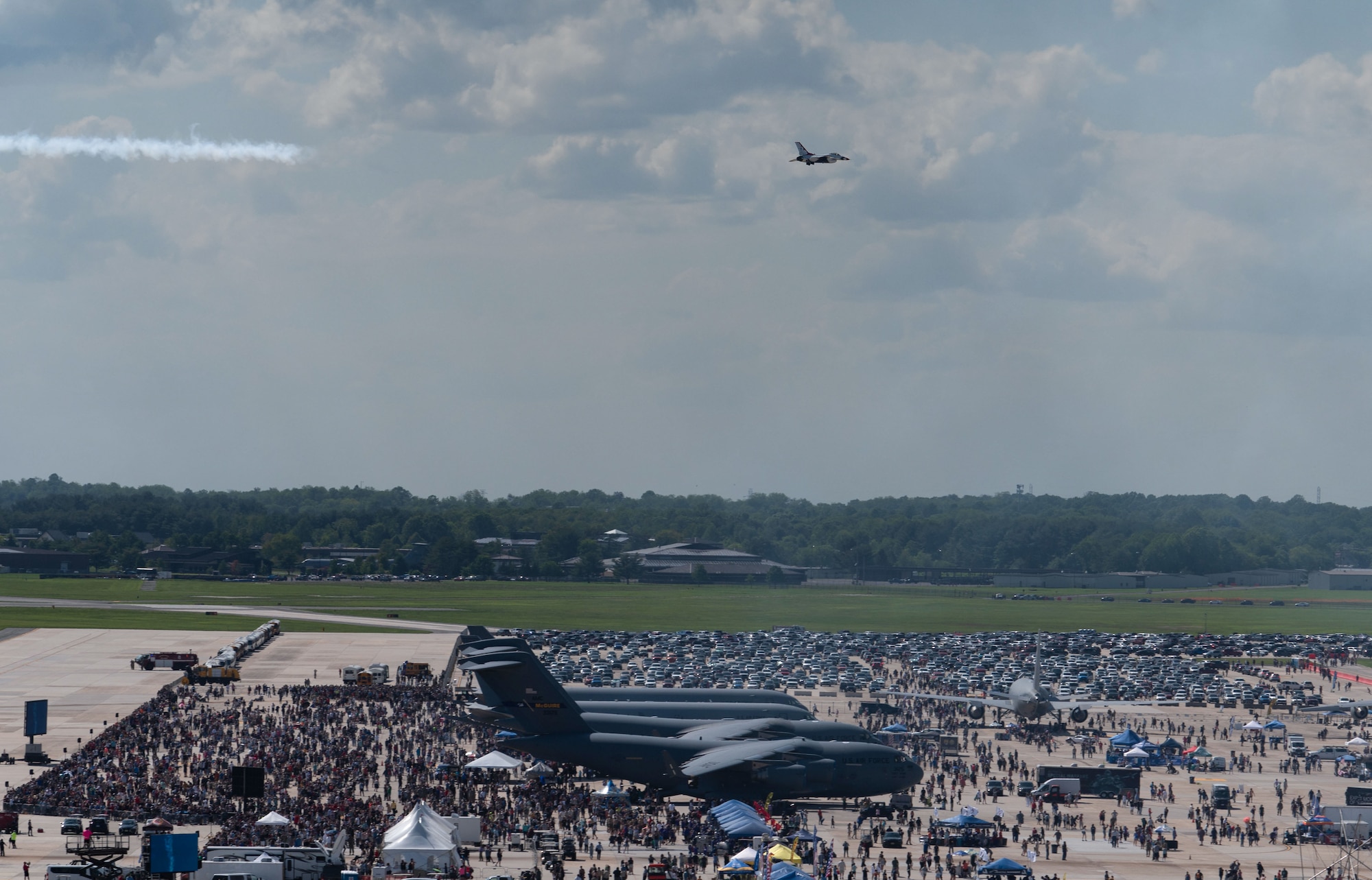 A U.S. Air Force Air Demonstration Squadron, “Thunderbird” F-16 Fighting Falcon aircraft flies over a large crowd while performing aerial maneuvers.