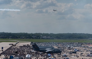 A U.S. Air Force Air Demonstration Squadron, “Thunderbird” F-16 Fighting Falcon aircraft flies over a large crowd while performing aerial maneuvers.
