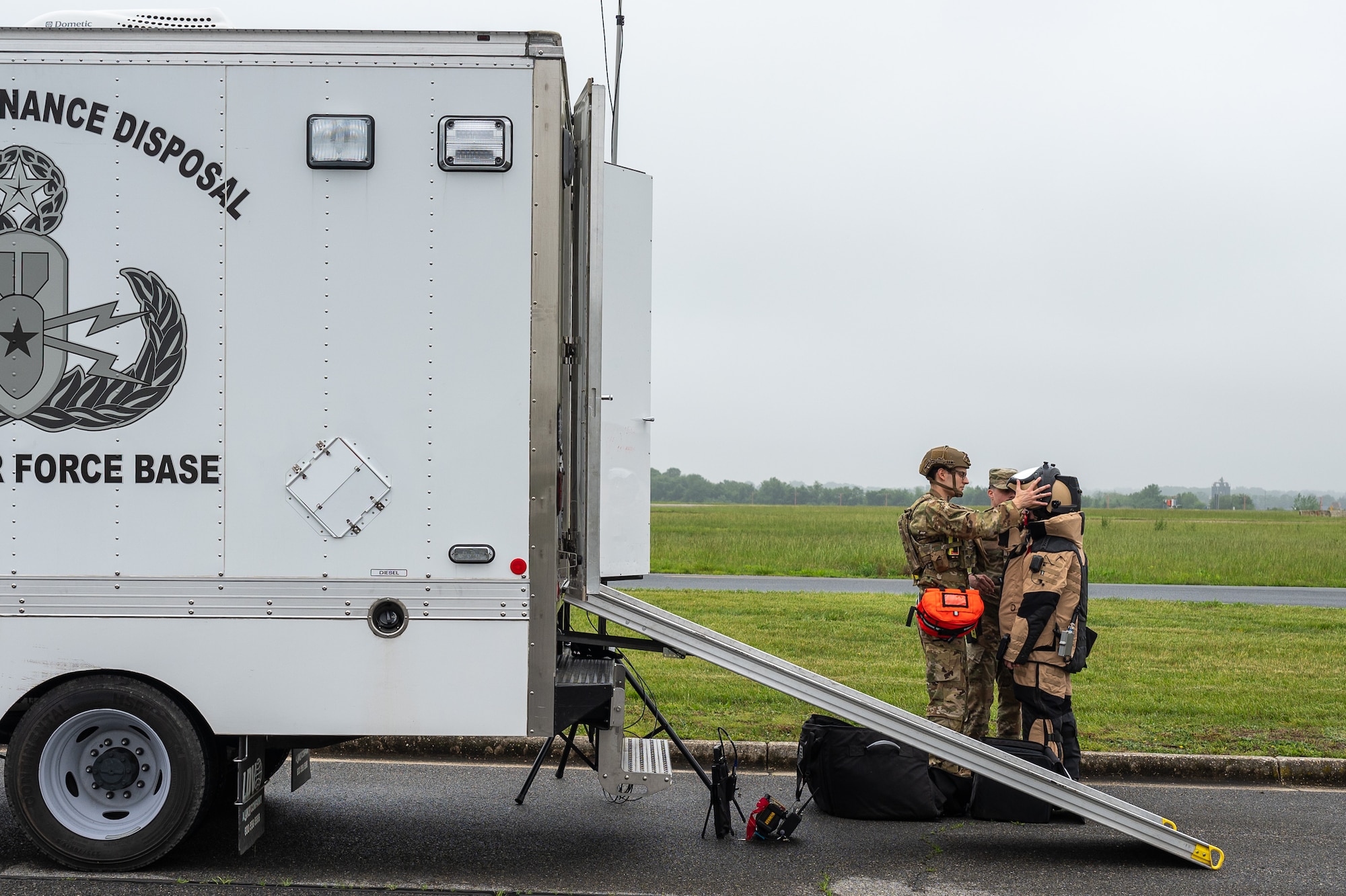 U.S. Air Force Staff Sgt. Luca Hillmeyer, left, 436th Civil Engineer Squadron explosive ordnance disposal technician, places an EOD 10 Bomb Suit helmet on Staff Sgt. Jordan Harper, right, 436th CES EOD technician during a peacetime improvised explosive device exercise at Dover Air Force Base, Delaware, May 14, 2025.