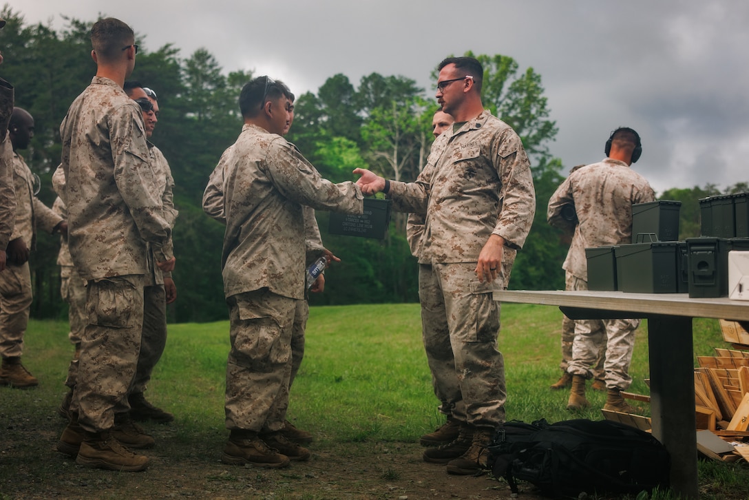 U.S. Marine Corps Staff Sgt. James Hart, a meterological analyst forecaster with Marine Corps Air Facility Quantico, right, hands ammunition to Marines with MCAF prior to an M240B machine-gun range at The Basic School on Marine Corps Base Quantico, May 15, 2025. Marines with MCAF embarked on a two-day field exercise including events such as land navigation, a mess night, a machine-gun range and culminating with a field exfiltration. (U.S. Marine Corps photo by Lance Cpl. Braydon Rogers)