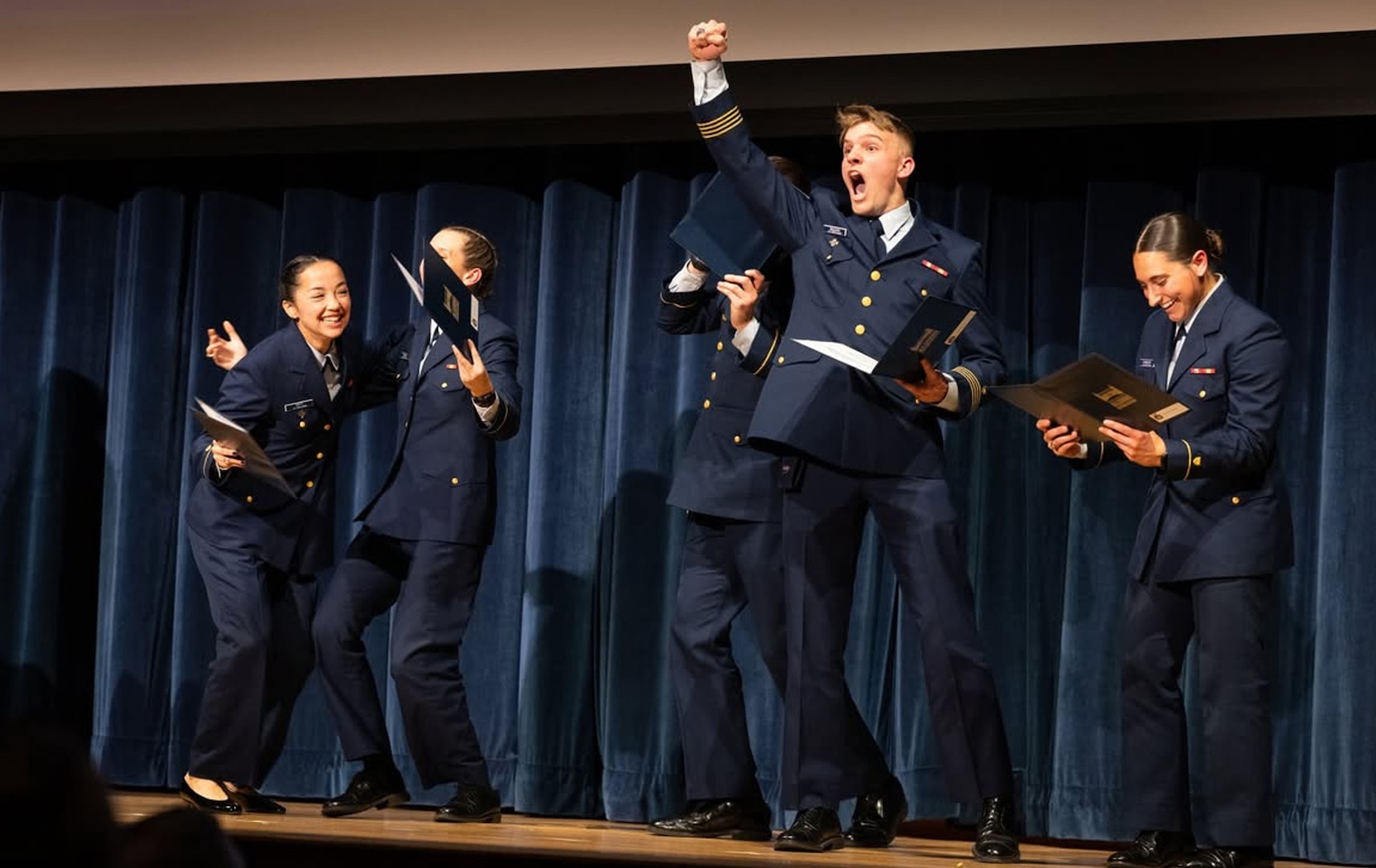 Cadets react to learning where they’ll be stationed after graduation at the 2025 Billet Night held March 6 at Coast Guard Academy (CGA) in New London, CT. For the first time this year, a matching algorithm was used to make assignments.