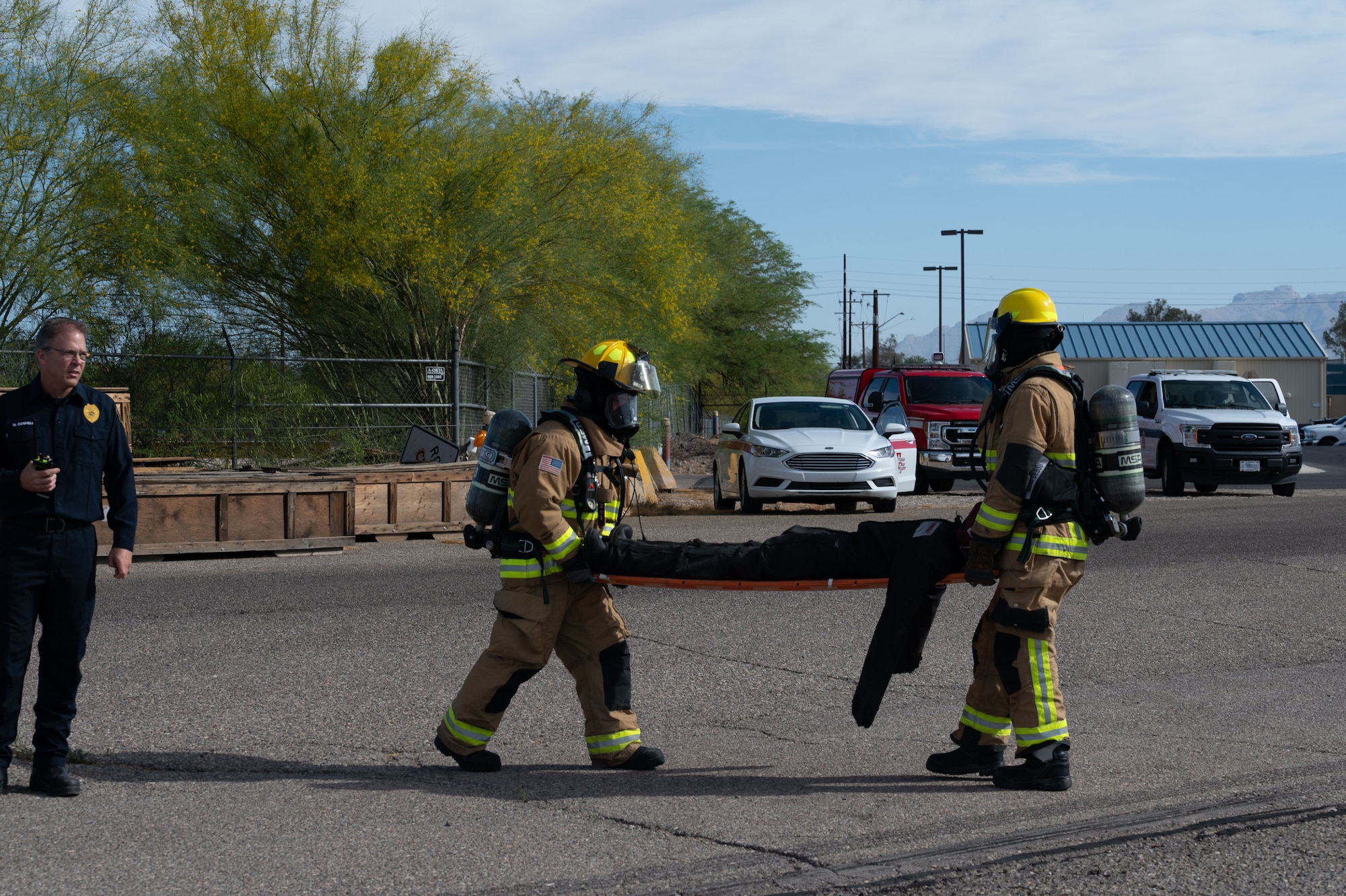 Emergency responders carry a simulated casualty away from the scene during a Mass Accident Response Exercise at Morris Air National Guard Base, Ariz., May 14, 2025. The 162nd Wing facilitates joint training exercises, such as a MARE, to improve interoperability and coordination between community partners. (U.S. Air National Guard photo by Staff Sgt. Guadalupe Beltran)