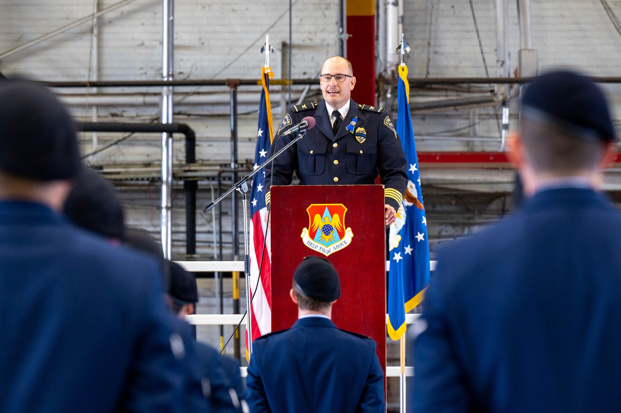 Kirk Brueeggeman, O’Fallon Chief of Police speaks during the closing ceremony of Nation Police Week at Scott. In the image standing in formation is the 375th SFS Airmen dressed in blues.
