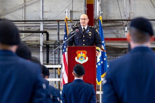 Kirk Brueeggeman, O’Fallon Chief of Police speaks during the closing ceremony of Nation Police Week at Scott. In the image standing in formation is the 375th SFS Airmen dressed in blues.