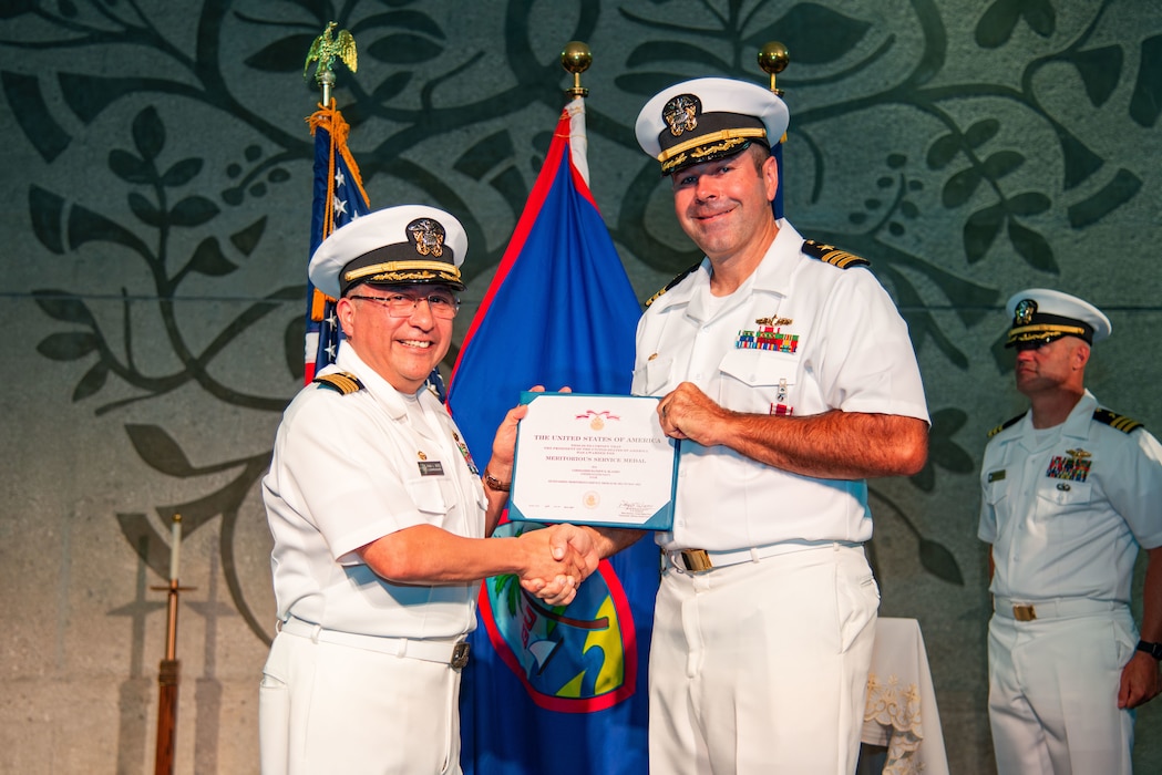 Capt. David Reyes, commodore, Military Sealift Command Far East, awards Cmdr. Kris Blandin with the Meritorious Service Medal during a change of command ceremony for MSC Ship Support Unit Guam at the Naval Base Guam chapel, May 16.