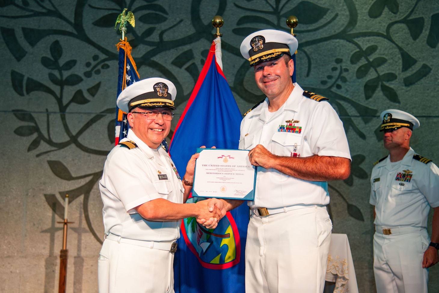 Capt. David Reyes, commodore, Military Sealift Command Far East, awards Cmdr. Kris Blandin with the Meritorious Service Medal during a change of command ceremony for MSC Ship Support Unit Guam at the Naval Base Guam chapel, May 16.