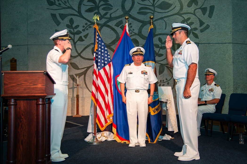 Capt. David Reyes, commodore, Military Sealift Command Far East, officiates the turnover between Cmdr. Kris Blandin, outgoing commanding officer of MSC Ship Support Unit Guam, and Cmdr. Paul Tortora, incoming commanding officer of MSC SSU Guam, during a change of command ceremony at the Naval Base Guam chapel, May 16.