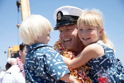 Master Chief Machinist's Mate (Auxiliary) Mitchell Gatton, Los Angeles-class fast-attack submarine USS Alexandria’s (SSN 757) chief of the boat, embraces his children as Alexandria returns to Naval Base Point Loma following a seven-month deployment to the U.S. Indo-Pacific Command area of responsibility, May 15, 2025.