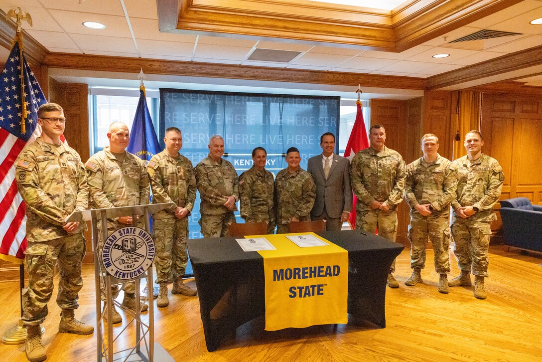 The recruiting and retention team of Kentucky National Guard poses for a photo with U.S. Army Maj. Gen. Haldane Lamberton, Kentucky’s adjutant general, and Dr. Jay Morgan, president of Morehead State University (MSU) after the signing of the memorandum of understanding (MOU) between MSU and KYNG at MSU in Morehead, Ky. on May 5, 2025. KYNG and MSU signed the MOU to give more educational benefits to Soldiers and Airmen of the KYNG. (U.S. Army National Guard photo by Andy Dickson)