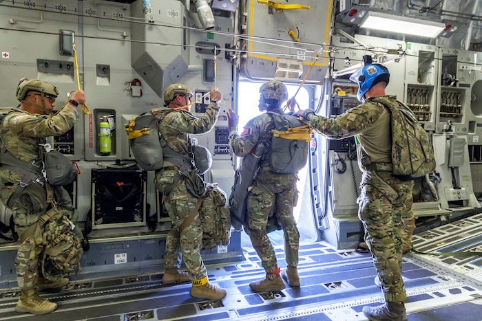 Tech. Sgt. Robert Gregory, 412th OSS SERE/TPP superintendent, prepares Army Civil Affairs troopers for a static line jump aboard a C-17 above Edwards Air Force Base, California, April 11. (Air Force photo by James West)