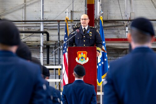 Kirk Brueeggeman, O’Fallon Chief of Police speaks during the closing ceremony of Nation Police Week at Scott. In the image standing in formation is the 375th SFS Airmen dressed in blues.