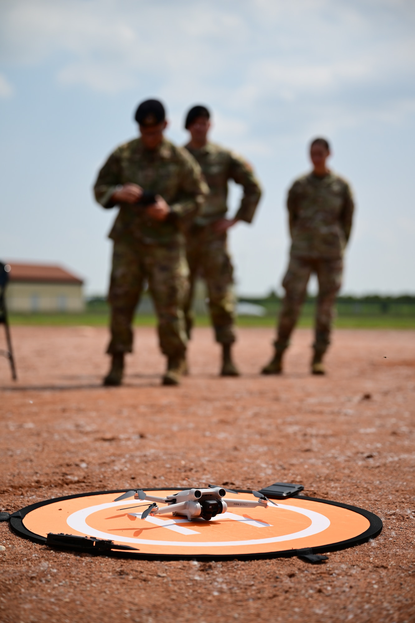 A drone sits on a landing pad.