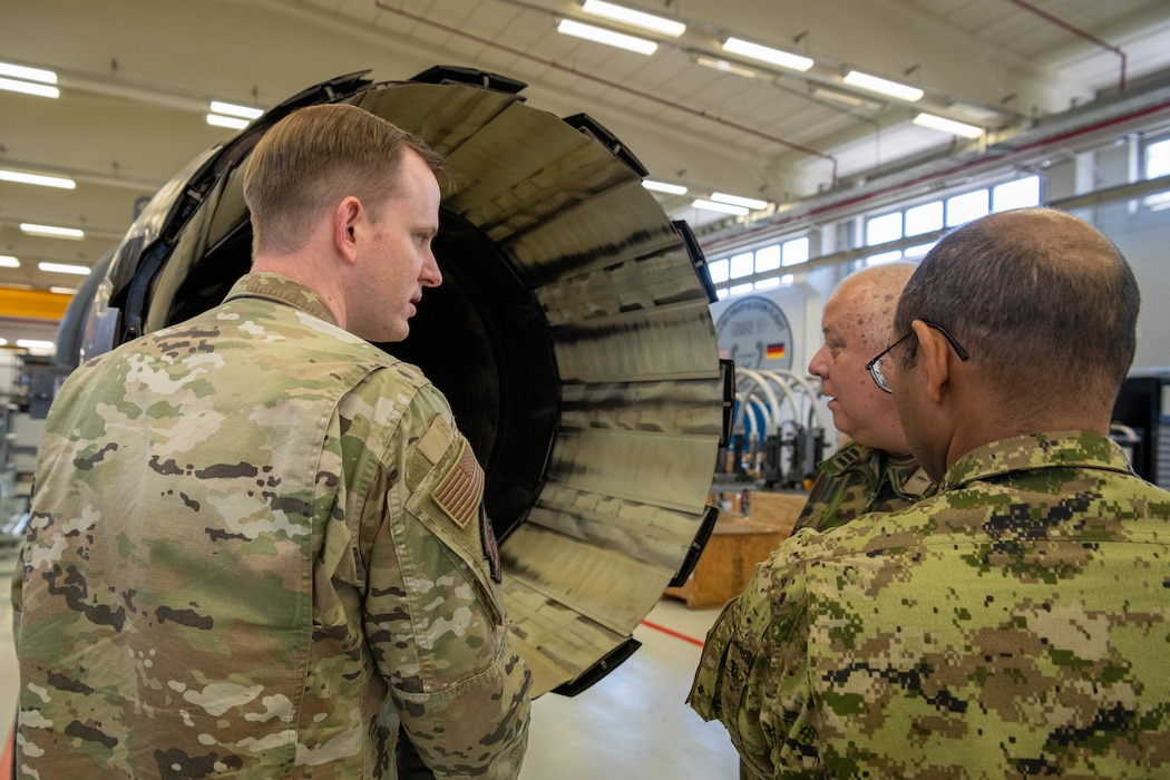 One U.S. Air Force member talks to a member of the Canadian military and a member of the German military.