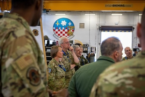 A group of military members from different Countries talk.