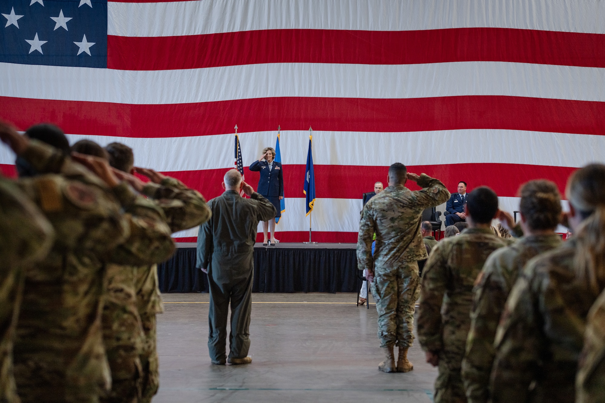 A group of uniformed airmen salute their new commander.