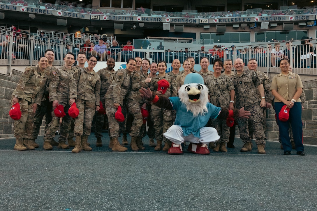 U.S. Servicemembers pose for a group photo at a Washington National’s baseball game for the Nats on Base Summit, Washington D.C., April 25, 2025. The summit is a yearly, widely attended gathering that allows base commanders and Pentagon staff to discuss ways to leverage the Washington Nationals military programming to best support servicemembers in the national capital region. (U.S. Marine Corps photo by Cpl. Casey Bonestroo)