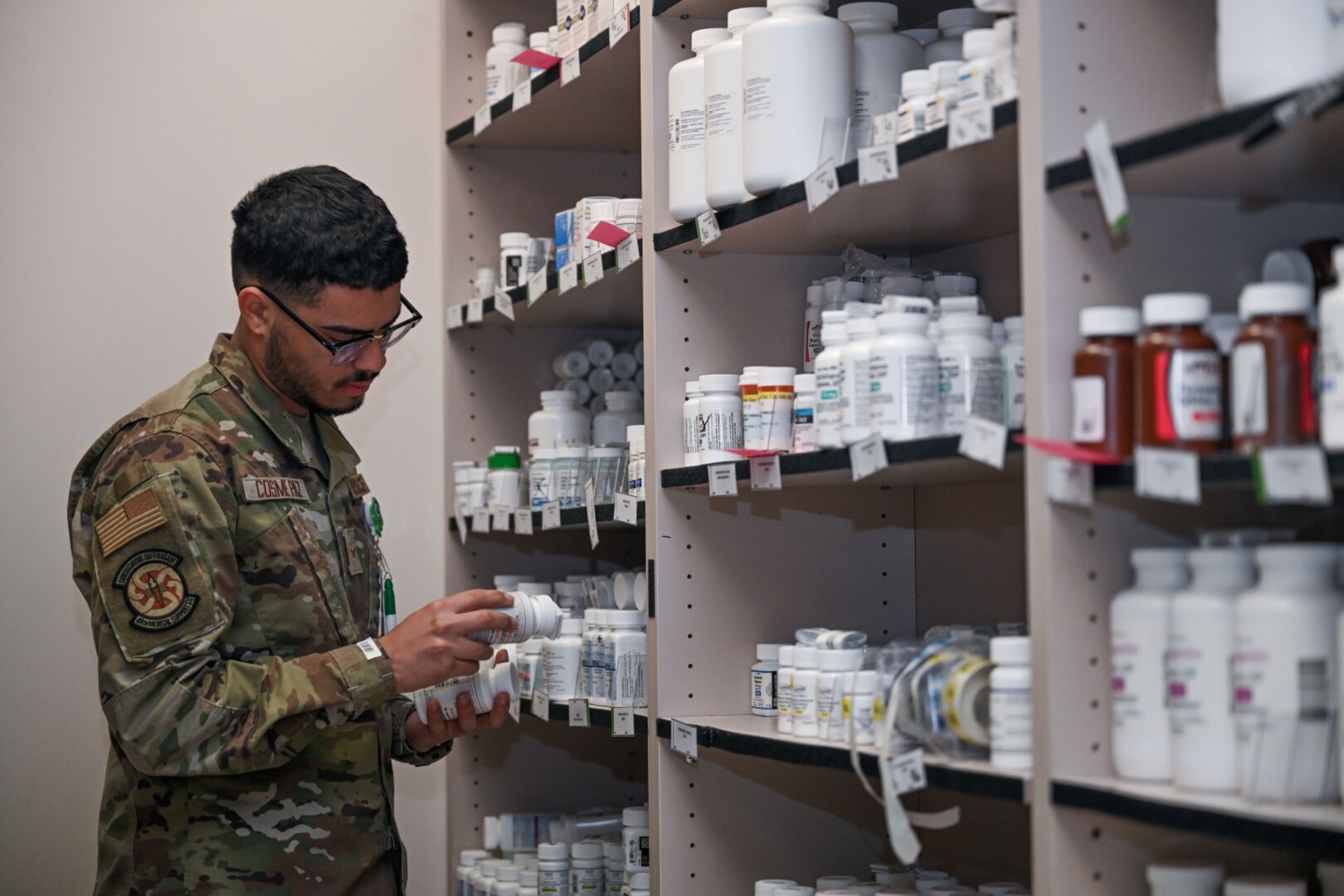 Service member examines medication at a military pharmacy.
