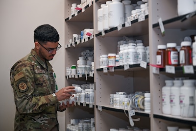 Service member examines medication at a military pharmacy.