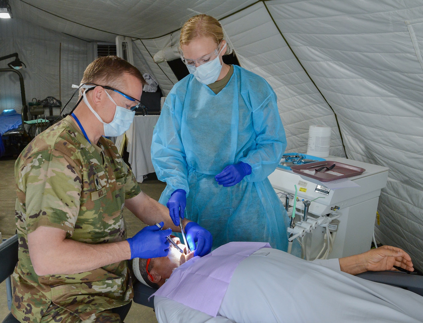 U.S. Air Force Lt. Col. Eric Mack, 129th Medical Group (MDG), part of the 129th Rescue Wing, California Air National Guard, and Staff Sgt. Hannah Potter, 124th MDG, Idaho Air National Guard, provide dental care to a Moroccan patient during the Humanitarian Civic Assistance event in Anzi, Morocco.