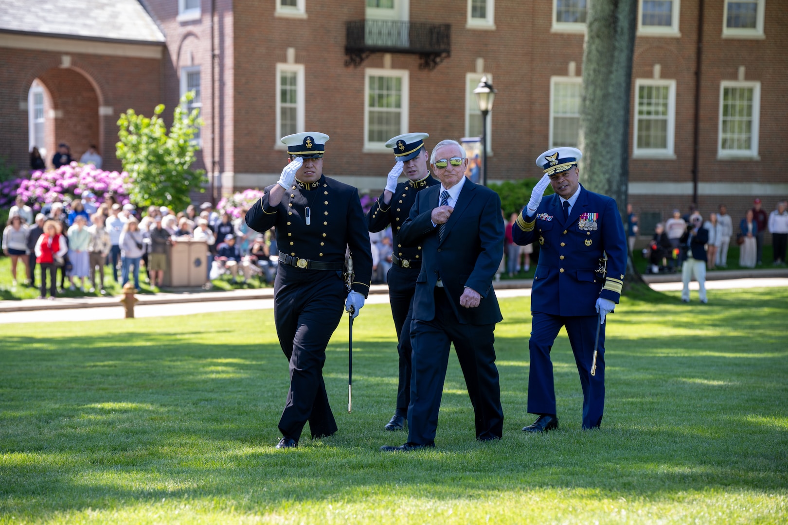 U.S. Coast Guard Academy (USCGA) Superintendent Rear Adm. Mike Johnston, Dr. James Tyler, and regimental staff (right to left) salute while passing a cadet company during regimental review at USCGA, New London, Connecticut, May 20, 2025. USCGA recognized Dr. James Tyler with the Scientæ Cedit Mare Award which reflects the importance of knowledge and education in mastering the challenges of the sea. (U.S. Coast Guard photo by Petty Officer Third Class Leo Avila.)