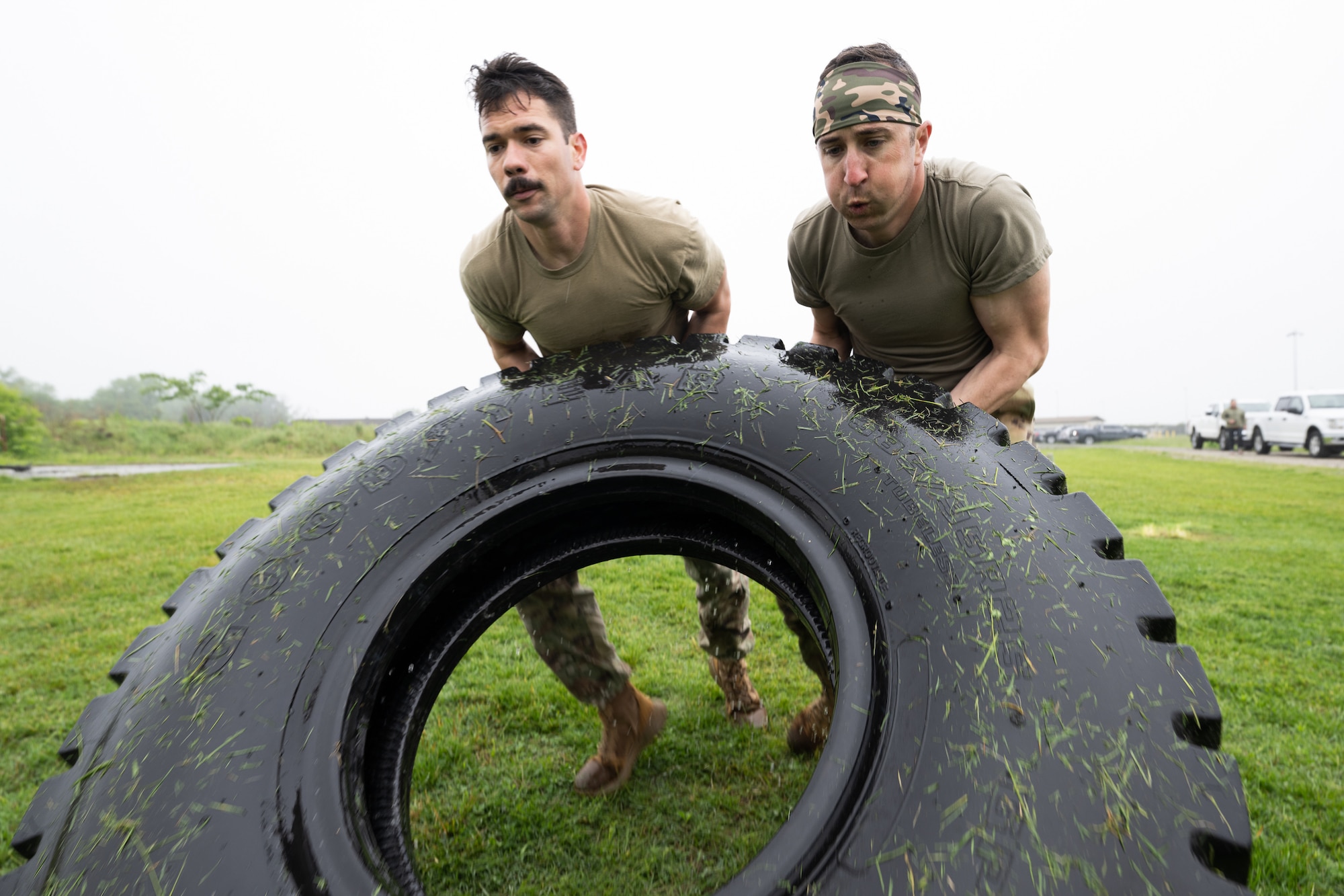 U.S. Air Force Staff Sgt. Joshua Williams, left, 436th Airlift Wing Chapel noncommissioned officer in charge of program support, and Capt. Ronald Gogan, 436th AW chaplain, flip a tire during the Defender Challenge at Dover Air Force Base, Delaware, May 14, 2025. The event, which entailed teams of two performing various physical challenges, was part of Dover AFB’s 2025 Police Week observance. (U.S. Air Force photo by Mauricio Campino)