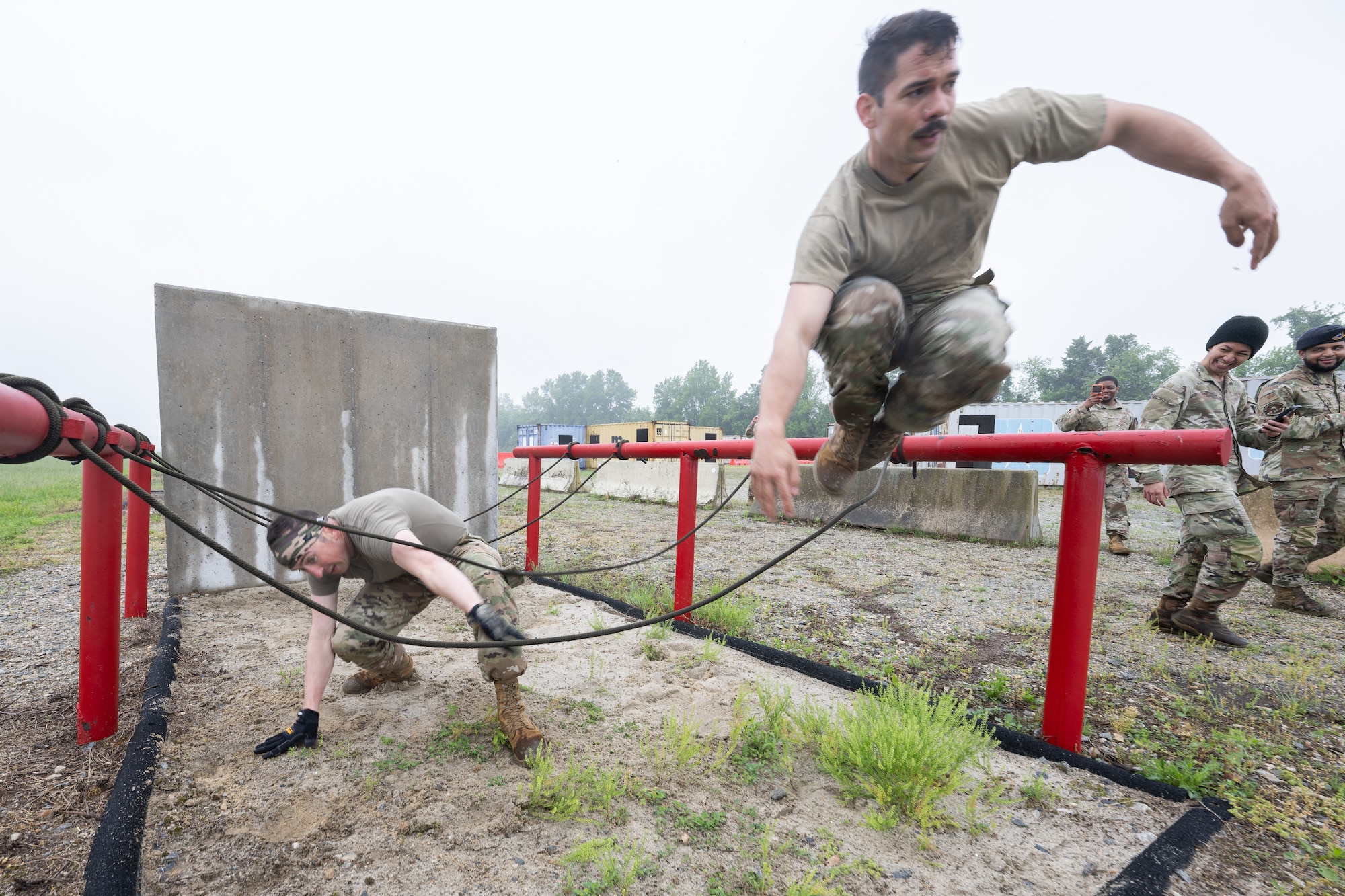 U.S. Air Force Staff Sgt. Joshua Williams, right, 436th Airlift Wing Chapel noncommissioned officer in charge of program support, and Capt. Ronald Gogan, 436th AW chaplain, maneuver through an obstacle course during the Defender Challenge at Dover Air Force Base, Delaware, May 14, 2025. The event,which entailed teams of two performing various physical challenges, was part of Dover AFB’s 2025 Police Week observance. (U.S. Air Force photo by Mauricio Campino)