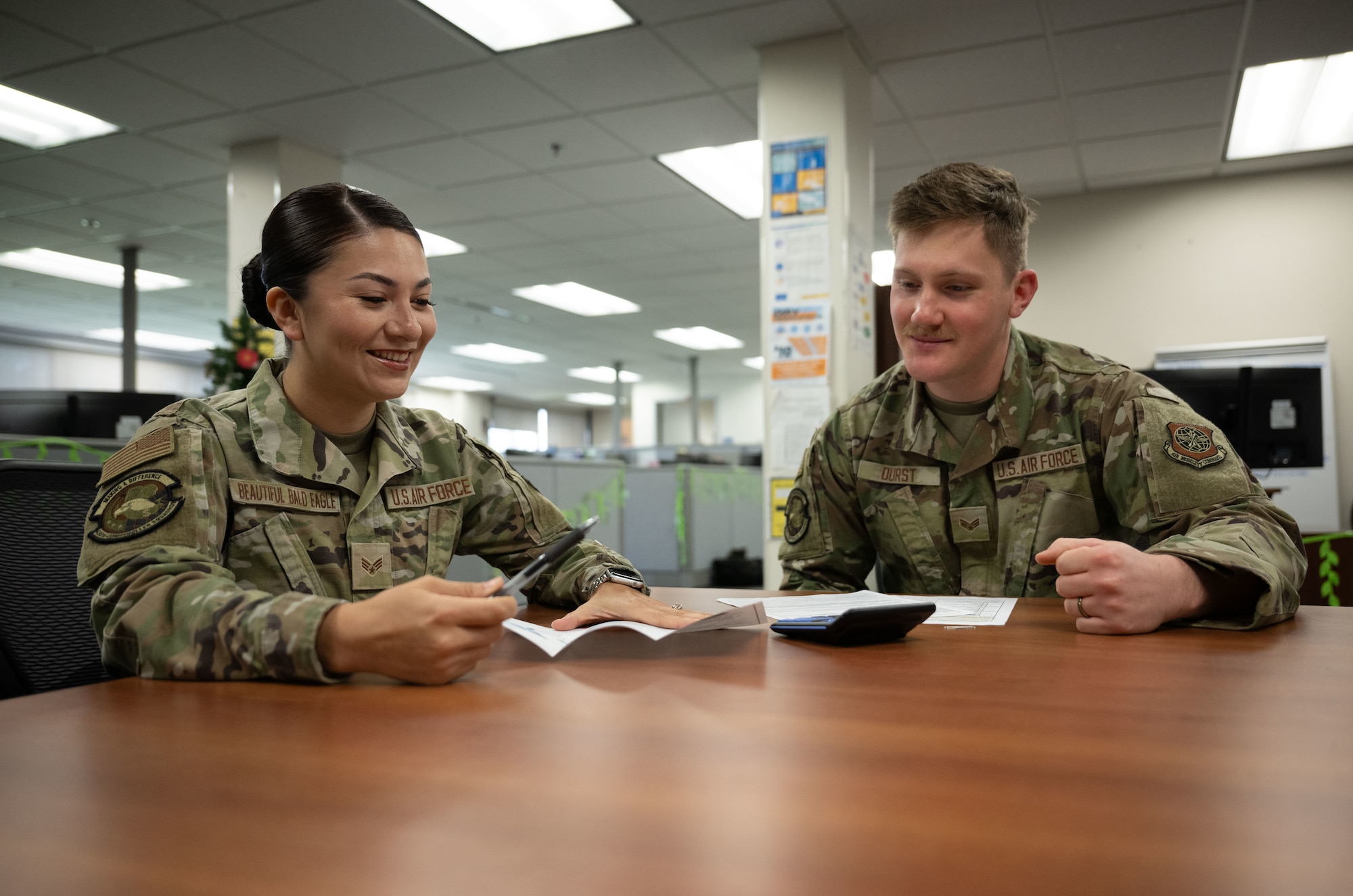 U.S. Air Force Senior Airman Destiny Beautiful Bald Eagle, left, and Senior Airman Jonah Durst, 436th Comptroller Squadron financial operation technicians, discuss a pamphlet at Dover Air Force Base, Delaware, April 29, 2025. The 436th CPTS is responsible for funds accounting and budget planning, programming, execution and analysis. The squadron also supports Air Mobility Command worldwide mobility requirements through funds disbursement, travel order processing and deployment of personnel. (U.S. Air Force photo by Airman 1st Class Liberty Matthews)