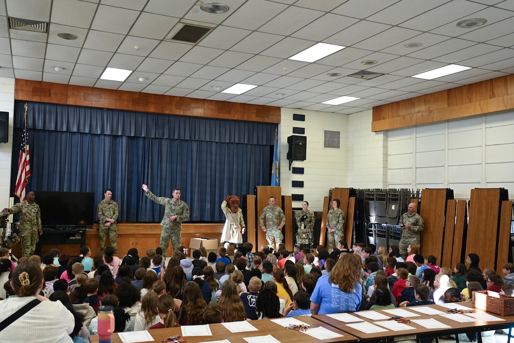 Airmen from the 97th Security Forces Squadron (SFS) brief students of L. Mendel Rivers Elementary School at Altus Air Force Base, Oklahoma, May 11, 2025. The 97th SFS demonstrated how to properly put on military gear and provided coloring sheets for children to create letters for deployed Airmen. (U.S. Air Force photo by Airman 1st Class Lauren Torres)