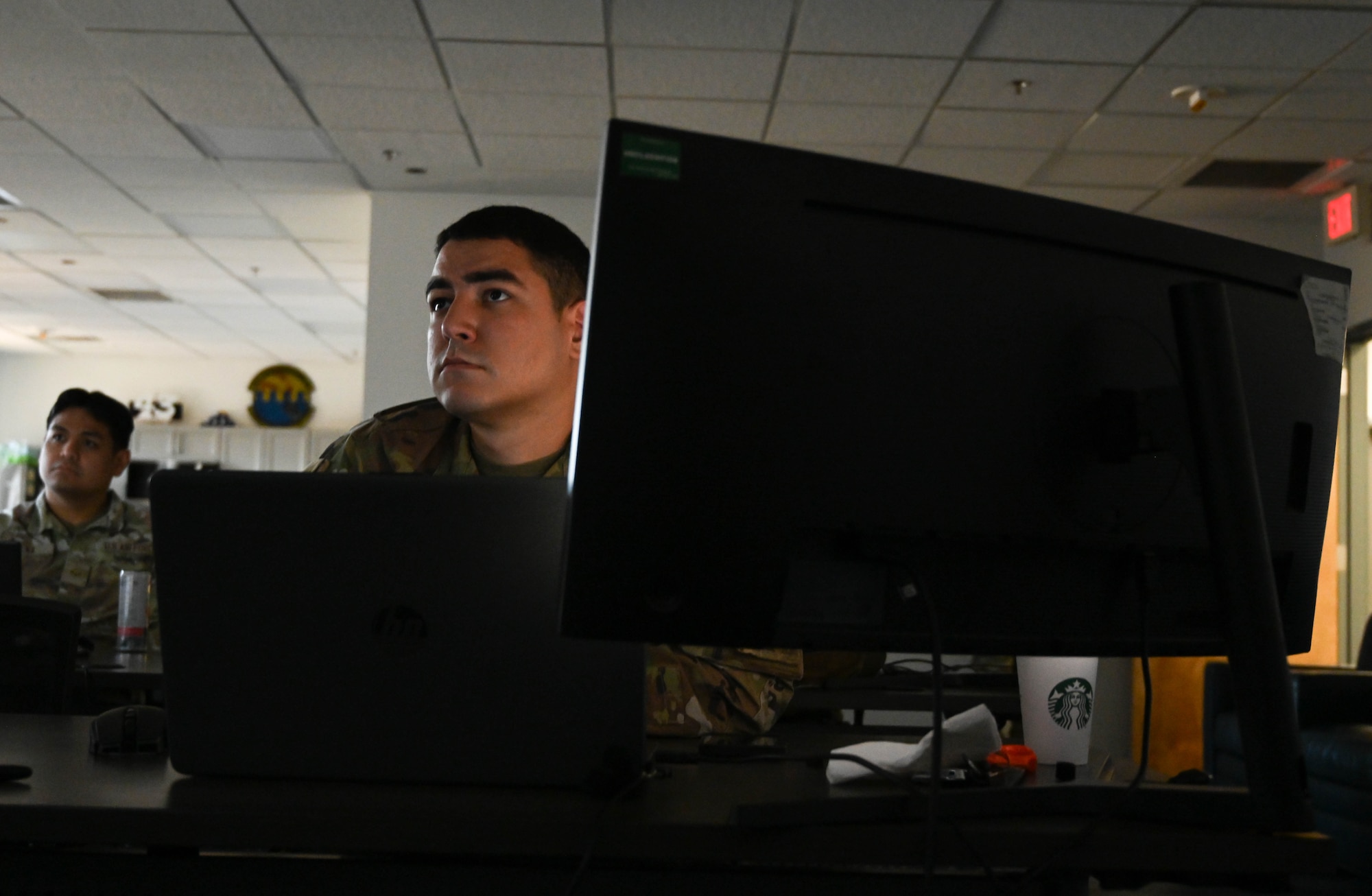 An Airmen sits in front of a computer.