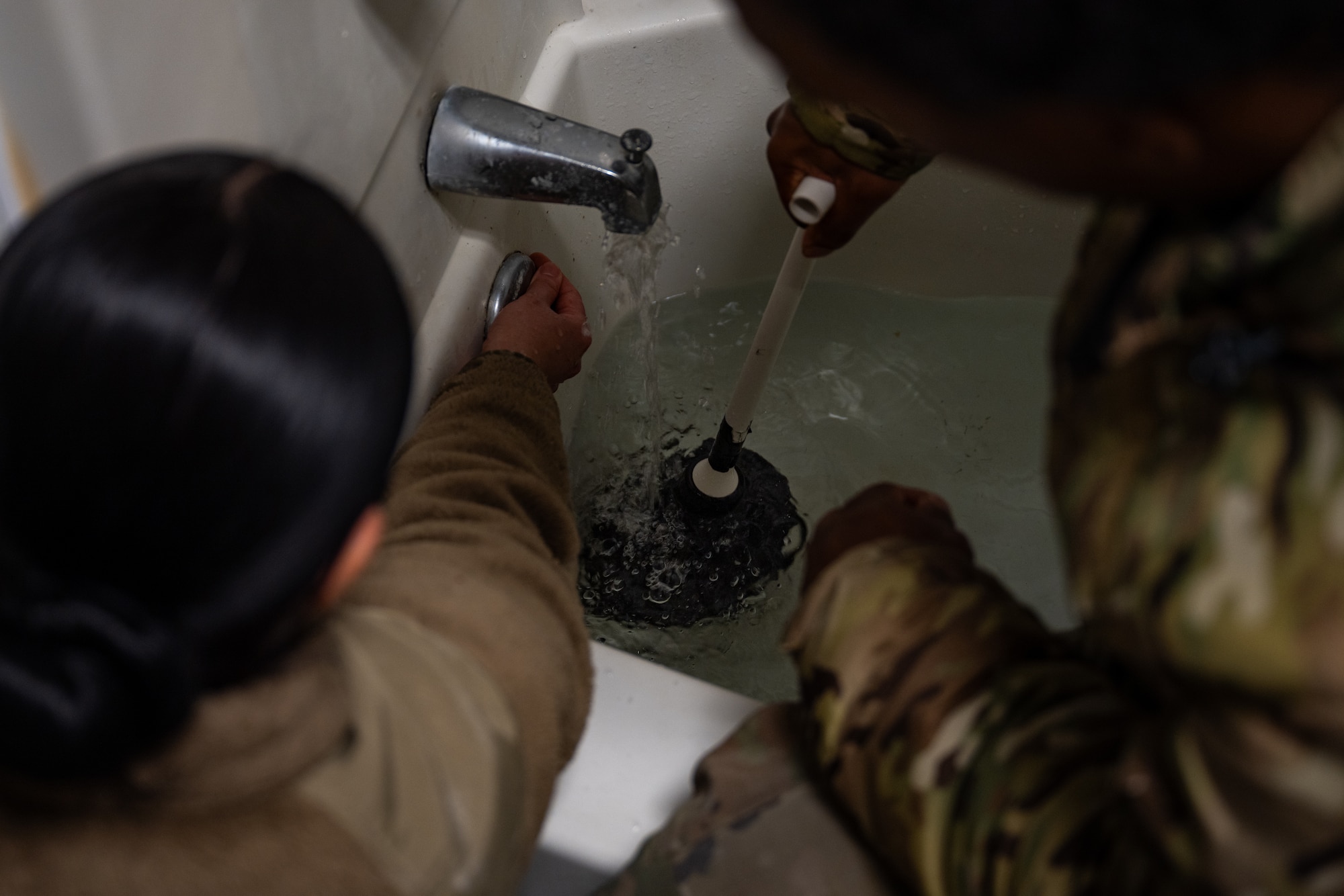U.S. Air Force civil engineers assigned to the 1st Special Operations Wing use a plunger to unclog a drain at Hurlburt Field, Florida, Jan. 13, 2025.