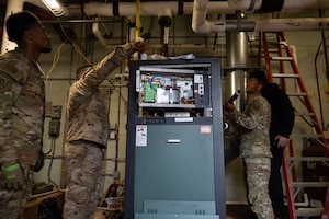 U.S. Air Force civil engineers assigned to the 1st Special Operations Wing attach a metal pipe to a gas valve on a boiler at Hurlburt Field, Florida, Jan. 13, 2025.