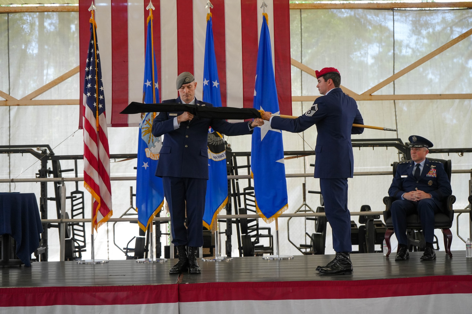 U.S. Air Force Command Chief Master Sgt. Stephen Cox, 24th Special Operations Wing, left, and Senior Master Sgt. Rob Henry, right, Air Force Special Operations Command Special Warfare Division, case the 24 SOW flag at the 24 SOW flag furling ceremony May 16, 2025, at Hurlburt Field, Fla.