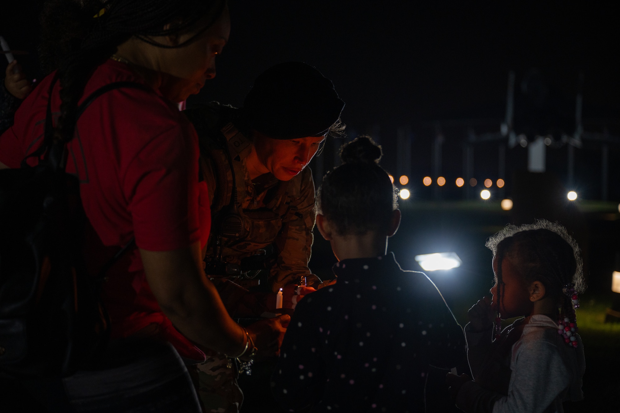 Airman lights a candle for a child. (U.S. Air Force photo by Airman 1st Class Skylar Ellis)